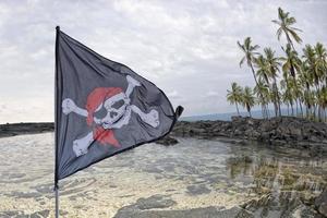 waving pirate flag jolly roger on sky background photo