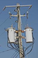 Electric cables tangle on wood post photo