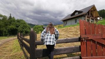 mujer joven que se retira en la casa de campo de la granja video