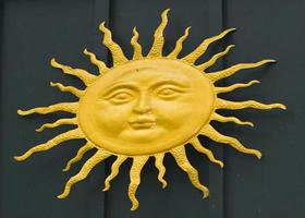 metal sun on green wood background photo