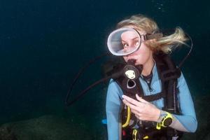 beautiful girl looking at you while swimming underwater photo