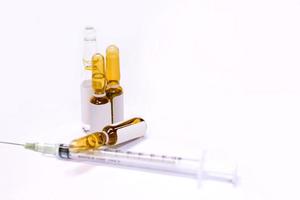 3 ml. brown Ampules of drug and plastic syringe on white background. photo