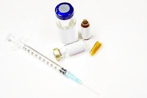 Plastic syringe put in a medical needle and vial bottles with 3 ml. ampule is opened isolate on white background. photo