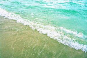 The light wave and beautiful green sea with space for texts on the beach background.. photo