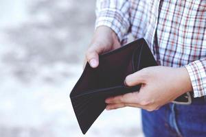 An Empty wallet in the hands of a young man photo