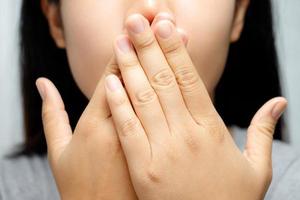 A disgusted girl is checking her breath. photo