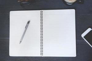 View from above of face sketch notepad and a pen on wooden background with copy space.  top view blank notebook and text. photo