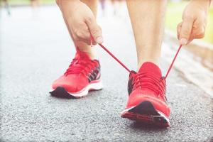 Running shoes. Barefoot running shoes closeup. male athlete tying laces for jogging on road. Runner ties  getting ready for training. Sport lifestyle. photo