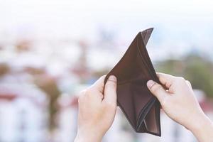 An Empty wallet in the hands of a young man photo