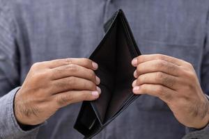 An Empty wallet in the hands of a young man photo