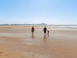The persons walk at Valdovino Beach. Valdovino, Galicia, Spain photo
