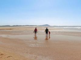 las personas caminan en la playa de valdovino. valdovino, galicia, españa foto