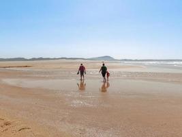 The persons walk at Valdovino Beach. Valdovino, Galicia, Spain photo