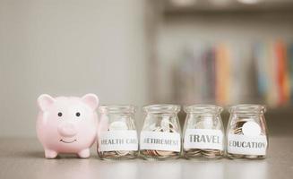 Message on paper and coins in glass jar, piggy bank, all on the table, concept of saving money financial growth preparation after retirement Managing savings for future goals, creating spending habits photo