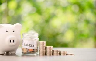 siveing message in a piece of paper and coins in a glass jar,all piggy bank on the table,savings concept,financial growth,retirement preparation Managing future funds, creating spending habits photo