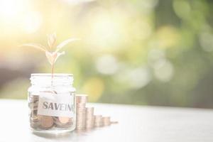 Message in a piece of paper and coins in a glass jar, stacked coins, savings ideas, financial growth, retirement preparations, creating spending habits, investing in financial assets. photo