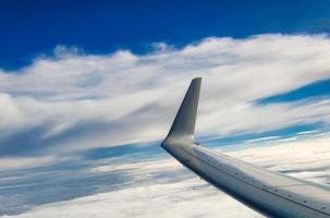 Airplane wing with clouds background and copyspace photo