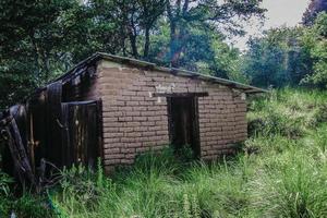 Rural house made of earth in green landscape photo