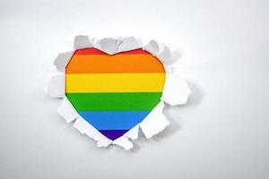 Hole in paper with heart shape and lgbt gay colors photo