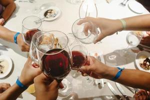 Group of people clinking wine glasses to celebrate photo