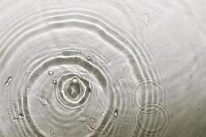 Water splash of falling drop with circular waves photo