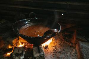 Mexican indigenous woman preparing Mole on a clay pot photo