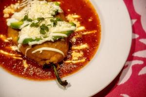 White plate with mexican stuffed chili chile relleno and copyspace photo