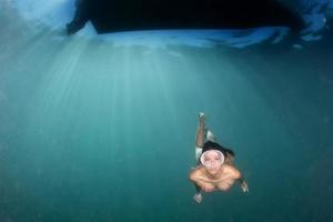 hermosa chica buceando en el mar azul profundo foto