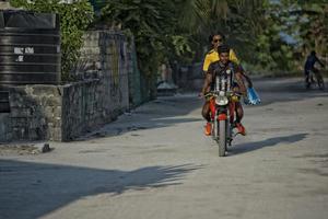 KONDEY, MALDIVES - MARCH, 12 2014 - Childrens and People in the street before evening pray time photo