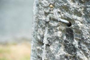 water falling from open tap fountain photo