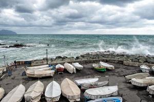 Barcos de pesca cubiertos por el mar en la tempestad en Génova, Italia foto