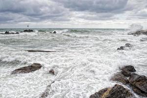 sea in tempest on rocks of italian village photo