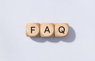 FAQ or Frequently Asked Questions concept. Text on Wooden cube blocks isolated on gray background photo
