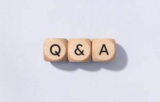 Q and A or questions and answers concept. Text on Wooden cube blocks isolated on gray background photo