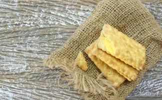 sandwich crackers with cream above sack bag on wood table photo