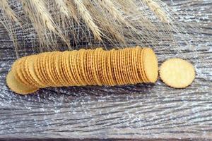 round cracker biscuits with barley plant on wood table photo