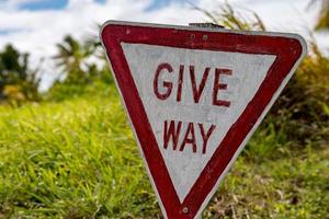 give way road sign on grass photo