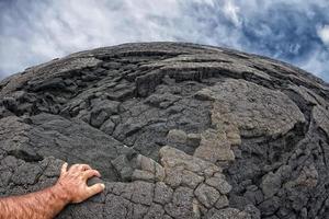 male hand on hawaiian black lava shore photo