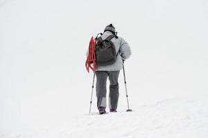 isolated snow shoe trekker walking on the snow photo