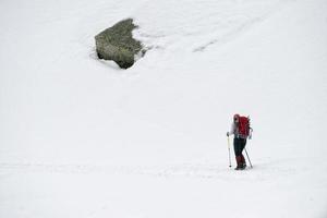 isolated snow shoe trekker walking on the snow photo