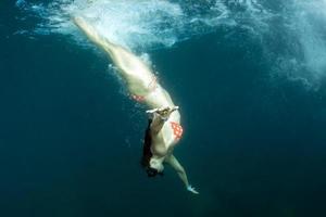 beautiful girl swimming under a ship photo