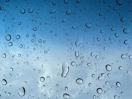 Water droplets perspective through glass surface against blue sky good for multimedia content backgrounds photo