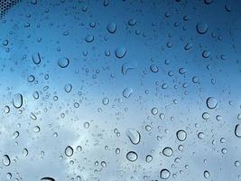 Water droplets perspective through glass surface against blue sky good for multimedia content backgrounds photo