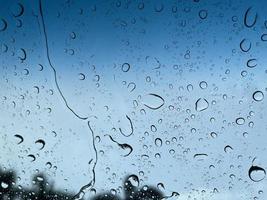 Water droplets perspective through glass surface against blue sky good for multimedia content backgrounds photo