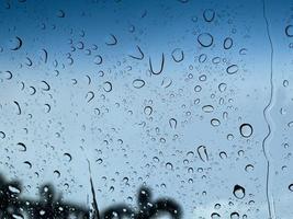 Water droplets perspective through glass surface against blue sky good for multimedia content backgrounds photo