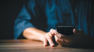 Closeup image of a man holding and using mobile phone or smartphone. photo