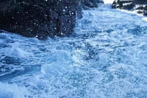 salpicaduras de agua cerca de rocas irregulares foto