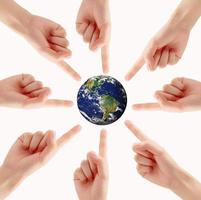 Conceptual symbol of a green Earth globe with multiracial human hands photo