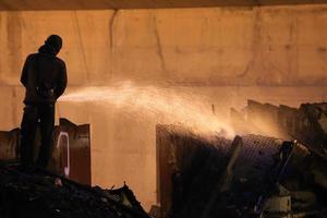 Silhouettes of  firemen before a fire photo