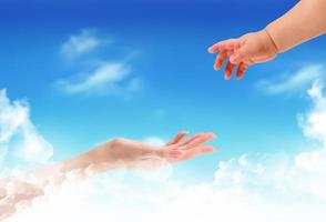 The children's hand reaches for a mother's hand against the blue sky photo